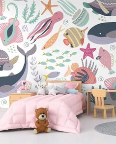 a child's bedroom decorated in pastel colors with under the sea wallpaper