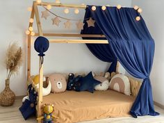 a child's bed with blue curtains and teddy bears