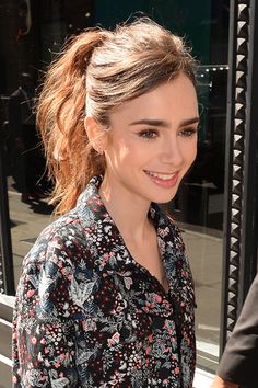 a close up of a person wearing a flowered shirt and smiling at the camera