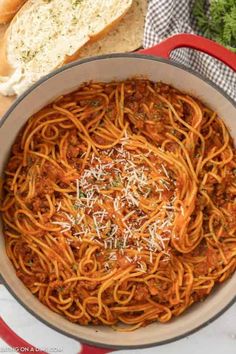 spaghetti with meat sauce and parmesan cheese in a pan