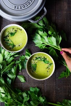 two bowls filled with green soup and garnished with parsley on the side