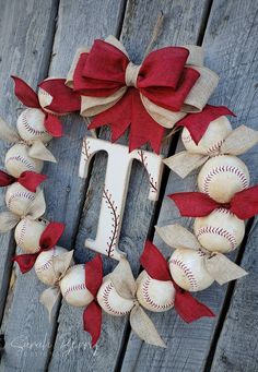 a baseball wreath with the letter t on it and some red bows hanging from it