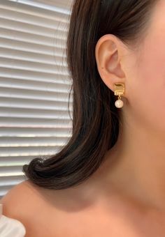 These captivating clip-on earrings feature a delicate golden square pendant embellished with a lustrous pearl. Our hypoallergenic clip-ons effortlessly blend style and comfort. No more tightness or hassle. Elevate your look effortlessly! *(Free Cushion Pad Included) Dimensions:  0.4"length X 1" height. Material:  High quality Copper with 14k Gold Plating + Pearl Free shipping on orders totaling $50 and up 🎁 Every order will be carefully packaged with love for delivery. 💕 Minimalist Accessories Jewellery, Minimalist Accessories, Ear Clips, Square Pendant, Earrings Wedding, Ear Jewelry, Pearl Drop Earrings, Pearl Drop, Gold Plating