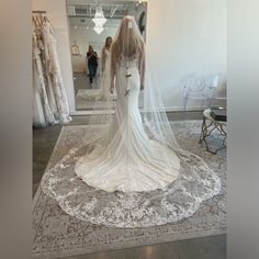 a woman in a wedding dress is looking at herself in the mirror while wearing a veil