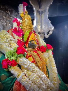 the statue is decorated with flowers and garlands