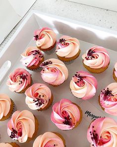 cupcakes with pink frosting in a white box