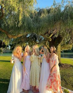 a group of women standing next to each other under a tree