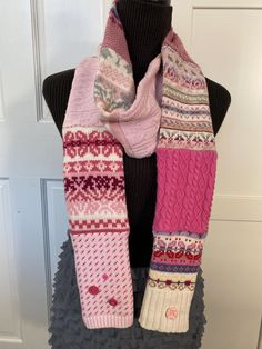 a pink and white scarf on top of a mannequin