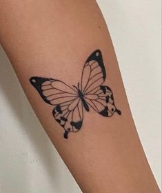 a black and white butterfly tattoo on the arm