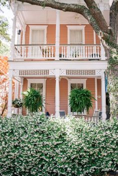 an orange house with white balconies and green plants