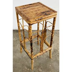 an old wooden table with metal bars on the top and bottom, sitting in a cement floor