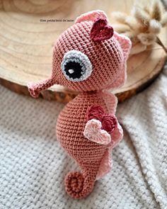 a crocheted pink stuffed animal with big eyes