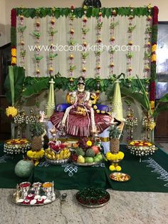 an idol sitting on top of a table covered in fruit