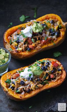 two stuffed sweet potatoes with black beans, guacamole and avocado