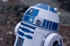 a star wars r2d2 robot is standing in the snow with its eyes open