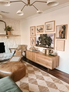 a living room with pictures on the wall and a fireplace in the corner next to it