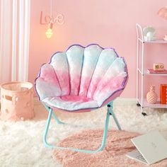 a pink and blue shell chair sitting on top of a white rug in a room