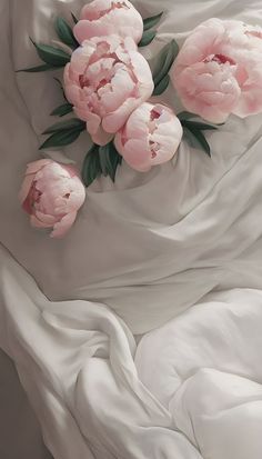 some pink flowers are laying on a white sheet