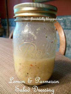 a mason jar filled with lemon and parmesan salad dressing on top of a table