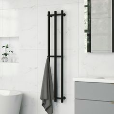 a white bathroom with a towel rack and bathtub