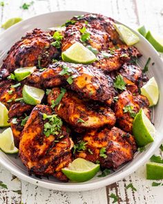 a white plate topped with chicken and limes