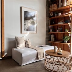 a living room filled with furniture and bookshelves next to a wall covered in shelves