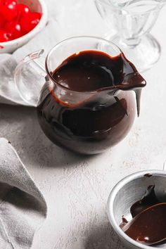 chocolate sauce being poured into a glass pitcher