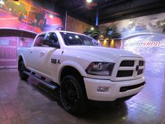 a white truck is parked in a showroom