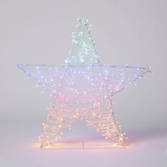 a lighted christmas star on a stand with white and pink lights in the shape of a star