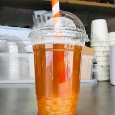 a plastic cup with a straw in it sitting on a table