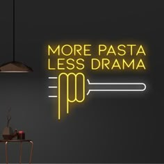 a neon sign that says more pasta less drama on the wall next to a table