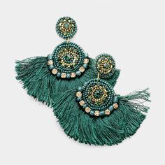 two pairs of green earrings with beads and tassels on the bottom, one in gold