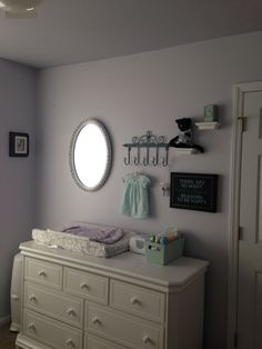 a baby's crib in the corner of a room next to a dresser