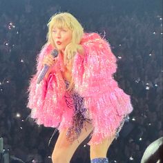 lady in pink outfit on stage with microphone