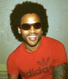 a man with an afro wearing sunglasses and a t - shirt that says adidas