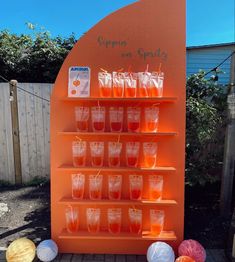 there are many cups and bags on this orange display case that is filled with liquid