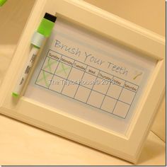 a white frame with a green marker and brush on it next to a toothbrush