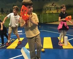 a group of children on a trampoline playing with an orange object in the air