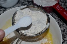 a spoon in a bowl filled with flour