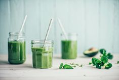 three mason jars filled with green smoothies