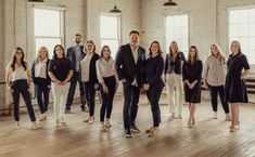 a group of people standing next to each other on a wooden floor in an office