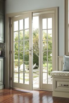 an empty room with french doors and wood flooring on the wooden floor next to a bench