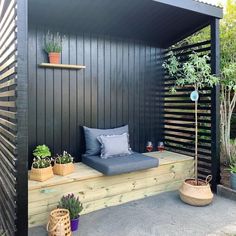 an outdoor bed with pillows and plants on it