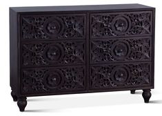 an ornately carved wooden cabinet with four doors and three drawers on one side,