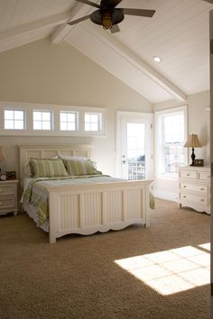 a bedroom with a bed, dressers and ceiling fan in it's center