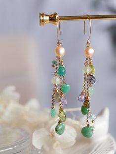 This beautiful pair of gemstone dropping earrings are made with handful of glamour green and blue colour multi gemstones. Each of them has carefully wired in 14K gold filled. Very detail art work and excellent quality of stones. They are Chalcedony, Peridot, Quartz, Chrysoprase, Pearl, Labradorite, Apatite, Prehnite, and Amethyst. The stones are dangling under a simple gold filled hooks. All jewellery in Artisan Made collection is unique and only one piece available. Let this unique piece be a p Green Multi-stone Drop Earrings, Green 14k Gold Filled Dangle Earrings, Green 14k Gold-filled Dangle Earrings, Green Multi-stone Earrings For Gift, Green Multi-stone Dangle Jewelry, Green Gemstone Dangle Chandelier Earrings, Dropping Earrings, Jewel Logo, Ear Art