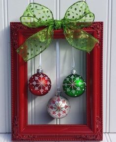 an image of christmas ornaments in a red frame on the wall with green ribbon and bow