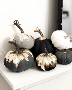 several black and white pumpkins sitting on top of a counter