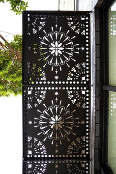 an intricately designed metal screen on the side of a building