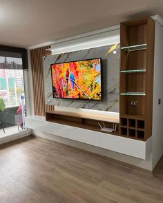 an entertainment center with a large television mounted on the wall